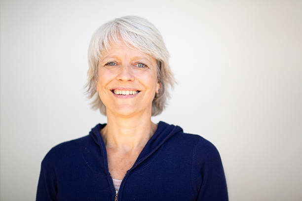 istock Mature woman smiling in navy blue jacket on white background 2252684721
