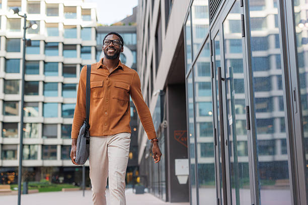 istock Young man walking confidently outdoors in a modern urban environment 2252685101