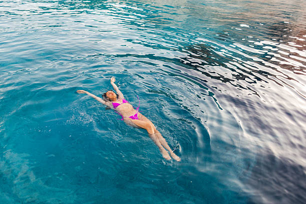 Three teenage girls swimming and enjoying in the blue ocean in the summertime.