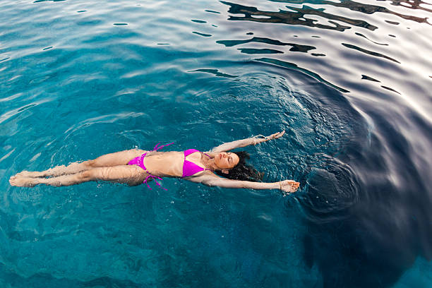 istock Woman floating on magical turquoise sea 2252685445