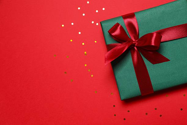 istock Top view of gift box tied with bow on red background 2252685585