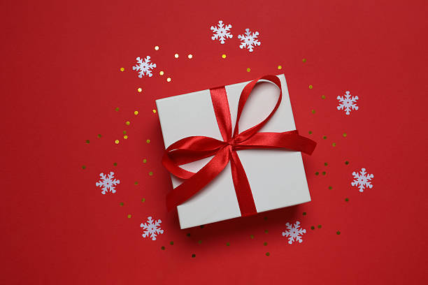 istock Top view of gift box tied with bow on red background 2252685613