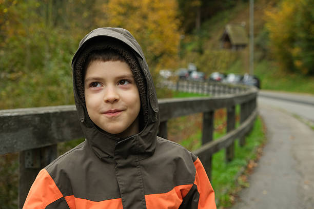 Child Outdoors in an Orange and Brown Jacket, Fall Season.