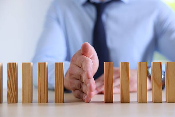 istock Risk. Man stopping domino effect at table, closeup 2252686551