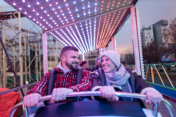 istock Smiling couple enjoying amusement park roller coaster ride 2252687898