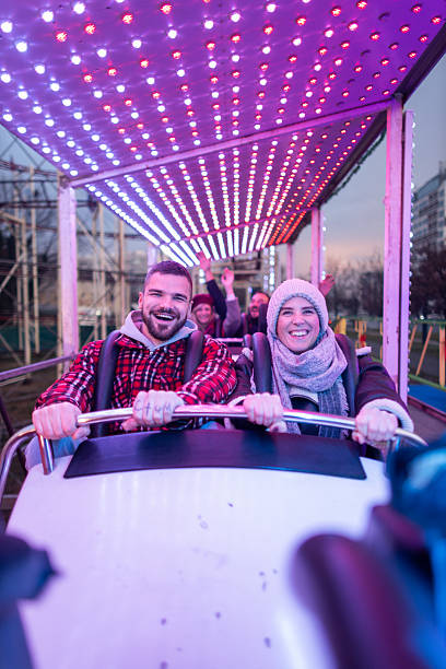 istock Happy couple enjoying amusement park ride at night 2252687901