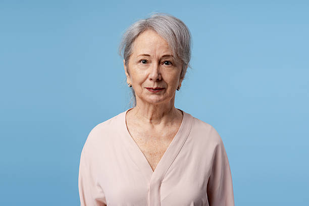 istock Senior woman posing looking at camera in studio with blue background 2252689264