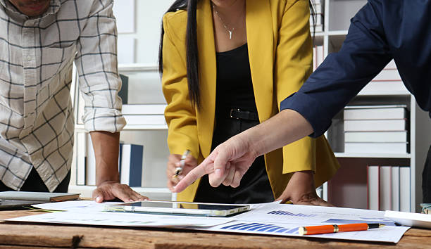 istock Business people working using tablet and documents in office meeting discussing strategy. Business colleagues collaborating on a project while analyzing financial statistics in office. 2252689969