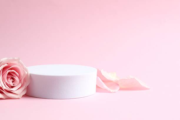 istock Pink rose petals with podium on color background 2252690003