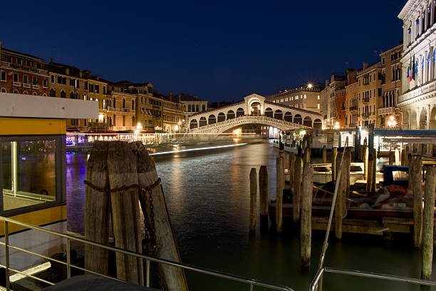 The Venetian river, surrounded by its houses, offers a long view with boats sailing by.