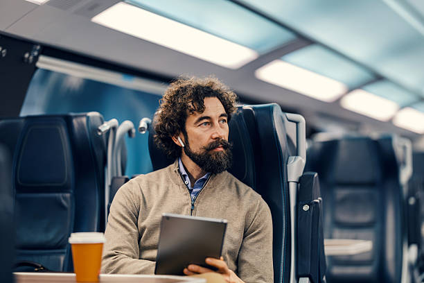 istock Mature adult man commuting on train using digital tablet 2252692128