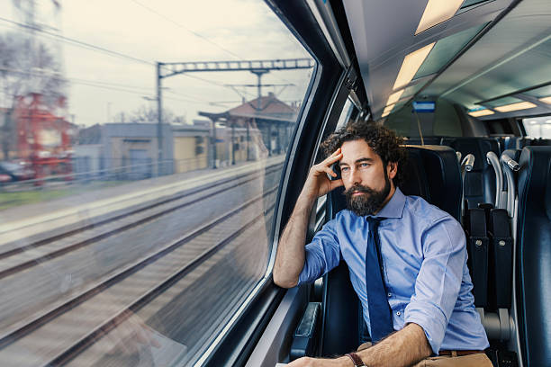 istock Businessman traveling by train looking out window thinking 2252692399