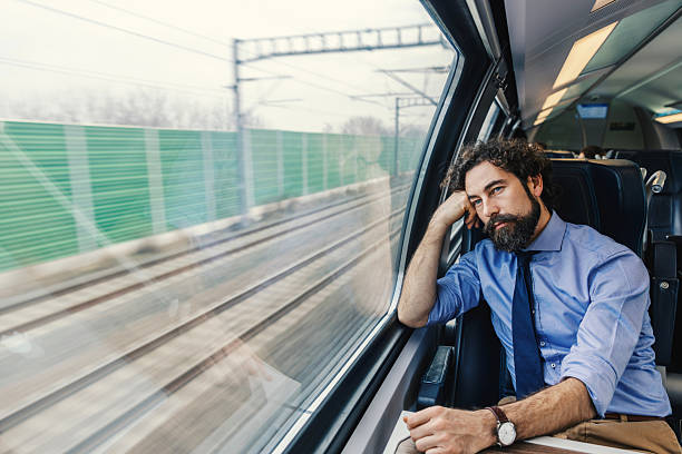 istock Businessman riding train looking out window thinking 2252692405