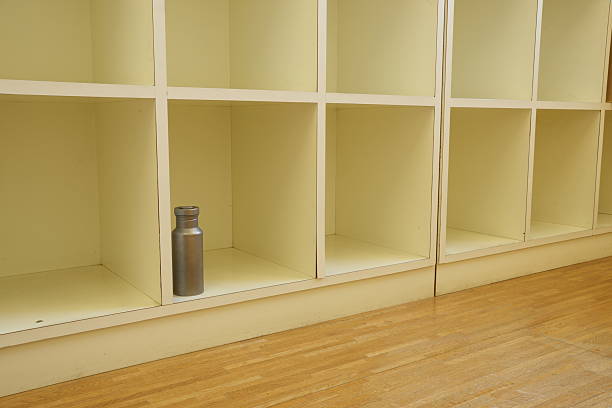 A metal water bottle sits on a shelf in a white closet