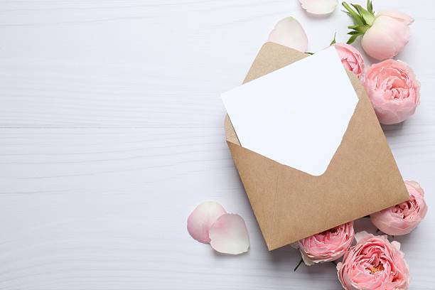 istock Beautiful composition with pink roses and paper envelope on white background 2252698157