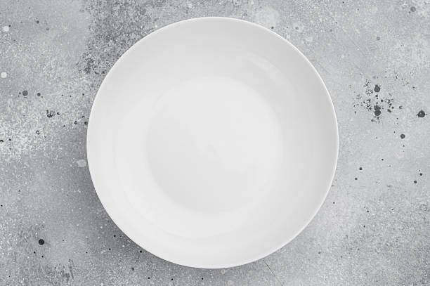 istock Minimal white plate on gray textured background. Elegant ceramic tableware mockup for food design and presentation 2252698825