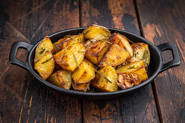 istock Baked potatoes with rosemary and garlic in cast iron pan. Simple rustic vegetable side dish overhead view 2252699788