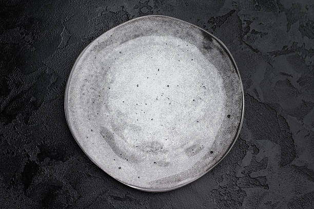 istock Gray matte plate overhead on dark background. Premium empty tableware with dramatic contrast 2252699967
