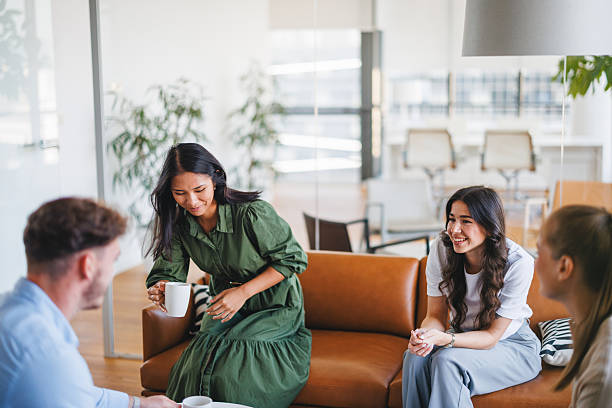 istock Happy Young Adults Chatting Over Coffee in Office Lounge 2252700025