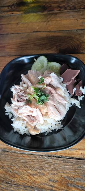 istock On the wooden table is chicken rice in a black plate. 2252701896