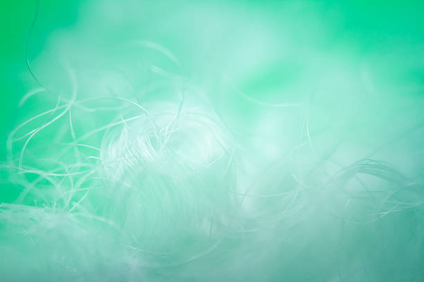 Extreme macro of polyester stable fiber on green background. Selective focus, shallow depth of field. Abstract dreamy background