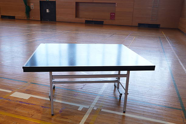 A ping pong table is sitting in a gymnasium