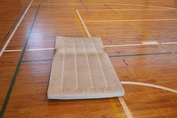Gymnastics training session led by a dedicated coach guiding athletes in a well-equipped facility. Emphasis on improving skills, teamwork, and motivation while fostering physical fitness and personal growth.