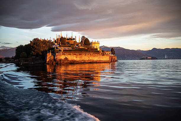 Borromeo Islands, Lake Maggiore, Northern Italian Lakes. View of Isola Bella island from a ship by sunrise. Beautiful colorful morning sky.