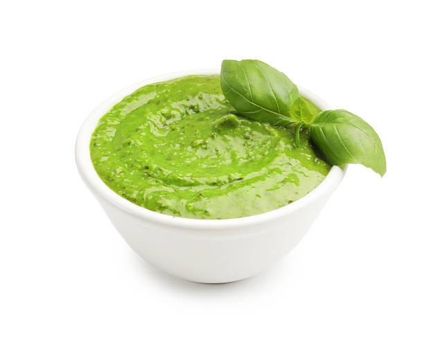 istock Pesto sauce with basil leaves in bowl isolated on white 2252713947