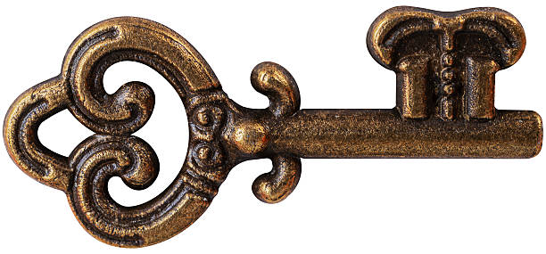 A macro shot of an antique, ornate wrought iron keyhole and a rusty key inserted into a rustic wooden drawer or cabinet door.