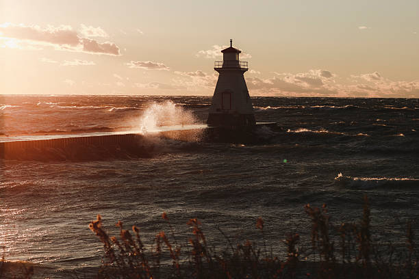 istock Lighthouse on Pier in Setting Sun and Rough Waters 2252719802