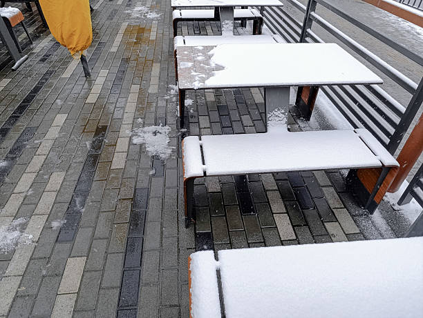 Outdoor cafe tables covered with snow. First snow concept