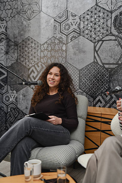 istock Relaxed Podcast Conversation With Woman Speaking Into Microphone In Modern Studio 2252720035