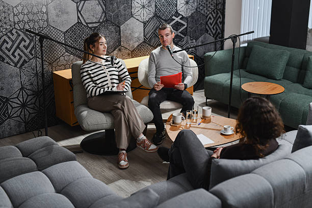 istock Cozy Podcast Studio Discussion With Hosts And Guest On Microphones In Modern Lounge Set 2252720768