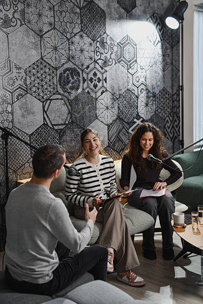 istock Casual Podcast Discussion With Microphones, Notes, And Lively Conversation In Cozy Studio Room 2252720833