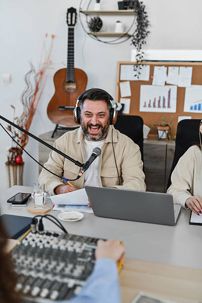 istock Smiling podcast guest laughing while responding to questions during a friendly interview recording session. 2252720992