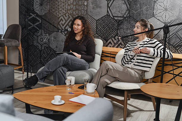istock Cozy Home-Style Podcast Studio With Two Women Hosts Sharing Coffee and Conversation 2252721602