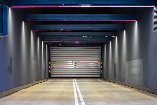 Modern underground parking entrance in Warsaw with LED lighting, roller shutter gate and symmetrical contemporary architecture
