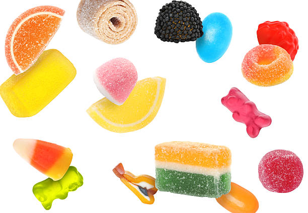 Different jelly candies falling against white background