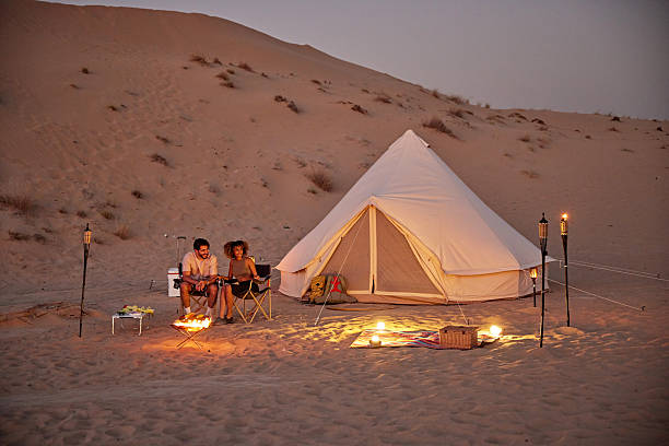 istock Couple glamping in desert at night by campfire 2252725798