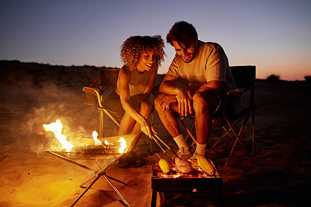 istock Couple camping desert at night cooking barbecue on campfire 2252725809