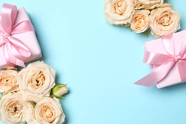 Beautiful composition with peony roses and gift boxes on color background