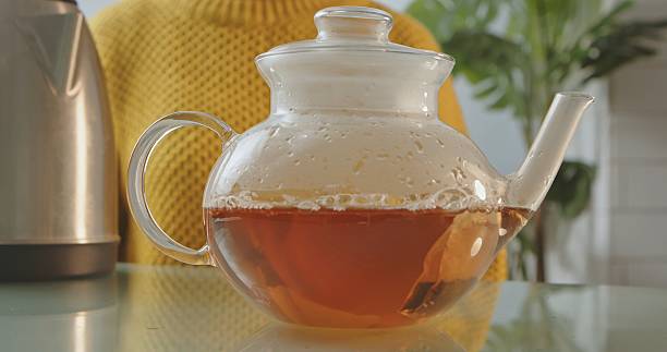 istock Glass Teapot with Freshly Brewed Tea and Yellow Sweater 2252727410
