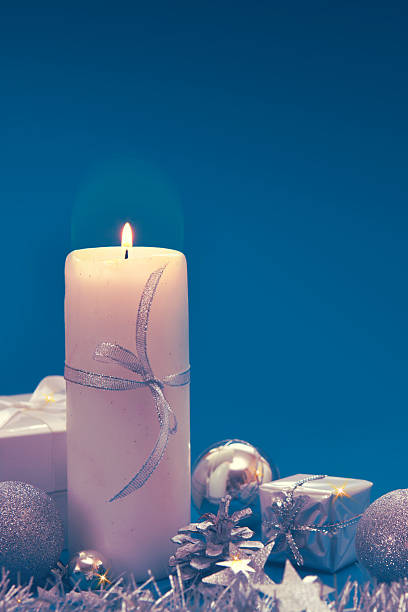 istock Advent candle with Christmas decoration isolated on blue background. 2252727677