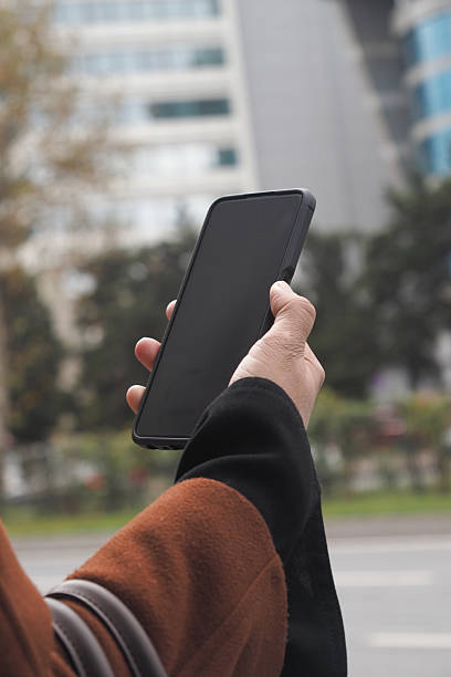 istock Holding a smartphone in an urban setting during the day 2252730918
