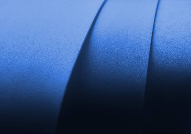 Abstract macro photograph of blue layered resistance band forming sculptural curves and deep shadows. The refined texture, tonal gradient, and negative space create a contemporary background suitable for fitness, strength, focus, performance, or modern visual storytelling.