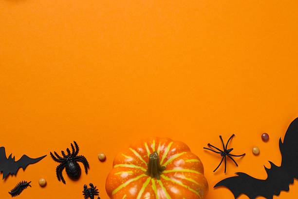 istock Halloween holiday decorations including pumpkins, spiders, bats on orange background 2252732390