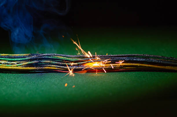 Smoldering electrical wires emit smoke and sparks when the system is dangerously overloaded.