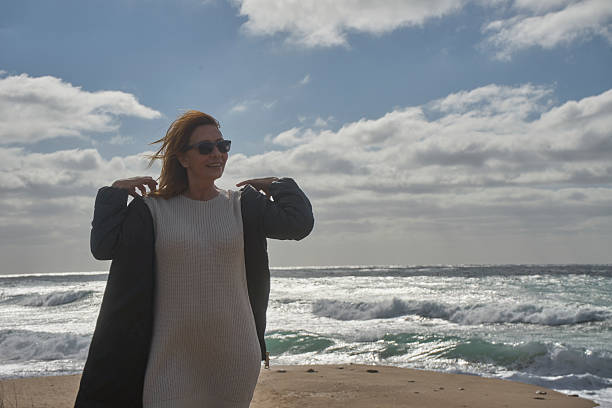 istock Woman enjoying windy day at a sunny beach 2252738265