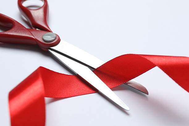 istock Stylish scissors and red ribbon on white background, flat lay with space for text. Ceremonial tape cutting 2252738967
